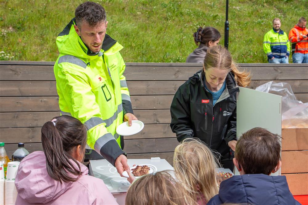 To voksne serverer kake til barna - Klikk for stort bilete