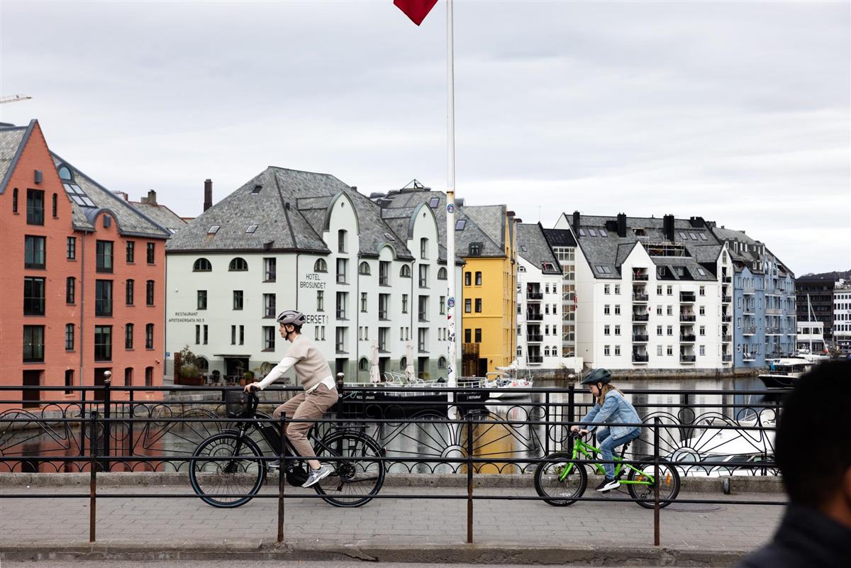 Mor og datter som syklar på Hellebrua i Ålesund sentrum. - Klikk for stort bilete
